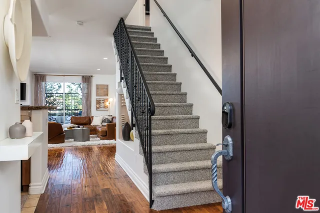 a view of entryway and hall with wooden floor