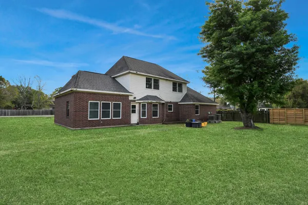 a large white kitchen with a sink and dishwasher a stove top oven with white cabinets