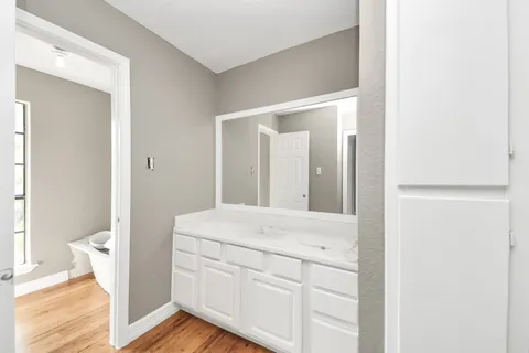 a view of a room with wooden floor and ceiling fan