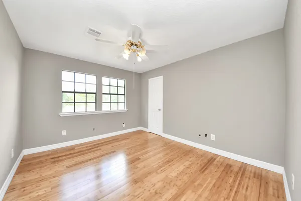 a view of a hallway with furniture and wooden floor