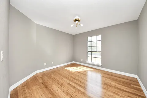 a view of a hallway with furniture and wooden floor