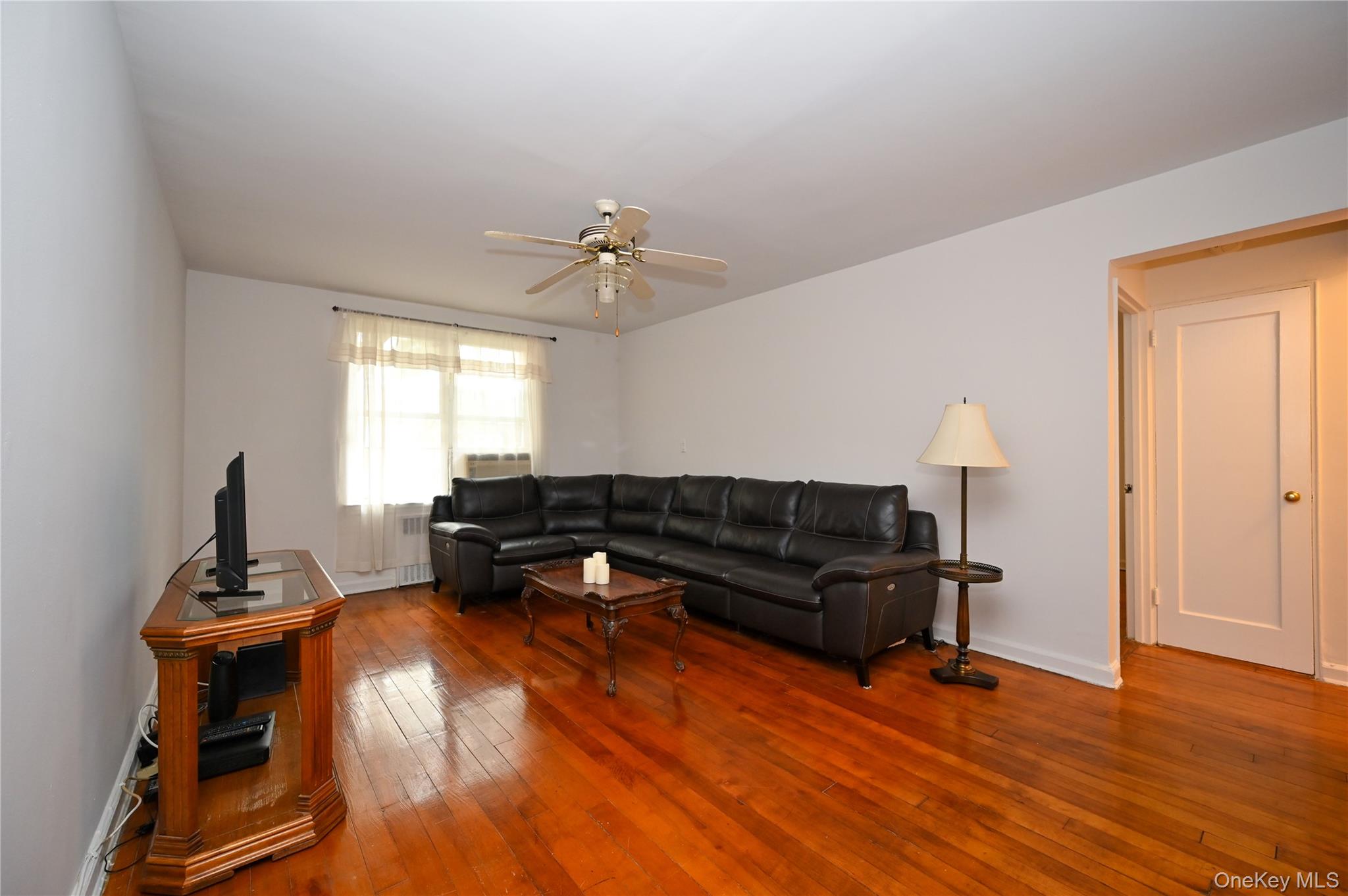 39-45 51st Street, Unit 1D Queens, NY 11377 - Photo 3 of 16 Living room with hardwood / wood-style flooring, a ceiling fan, and radiator heating unit