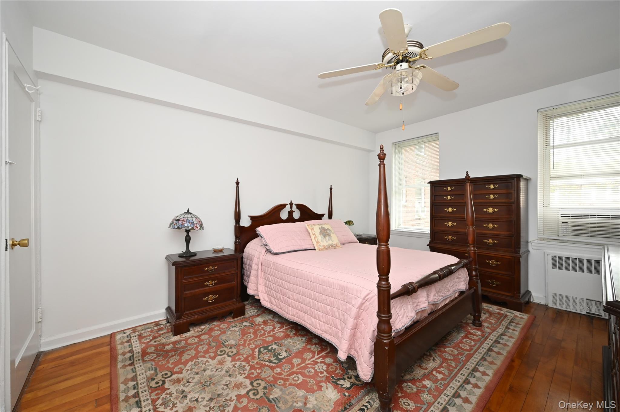 39-45 51st Street, Unit 1D Queens, NY 11377 - Photo 10 of 16 Bedroom with dark wood-style floors, radiator heating unit, ceiling fan, and cooling unit