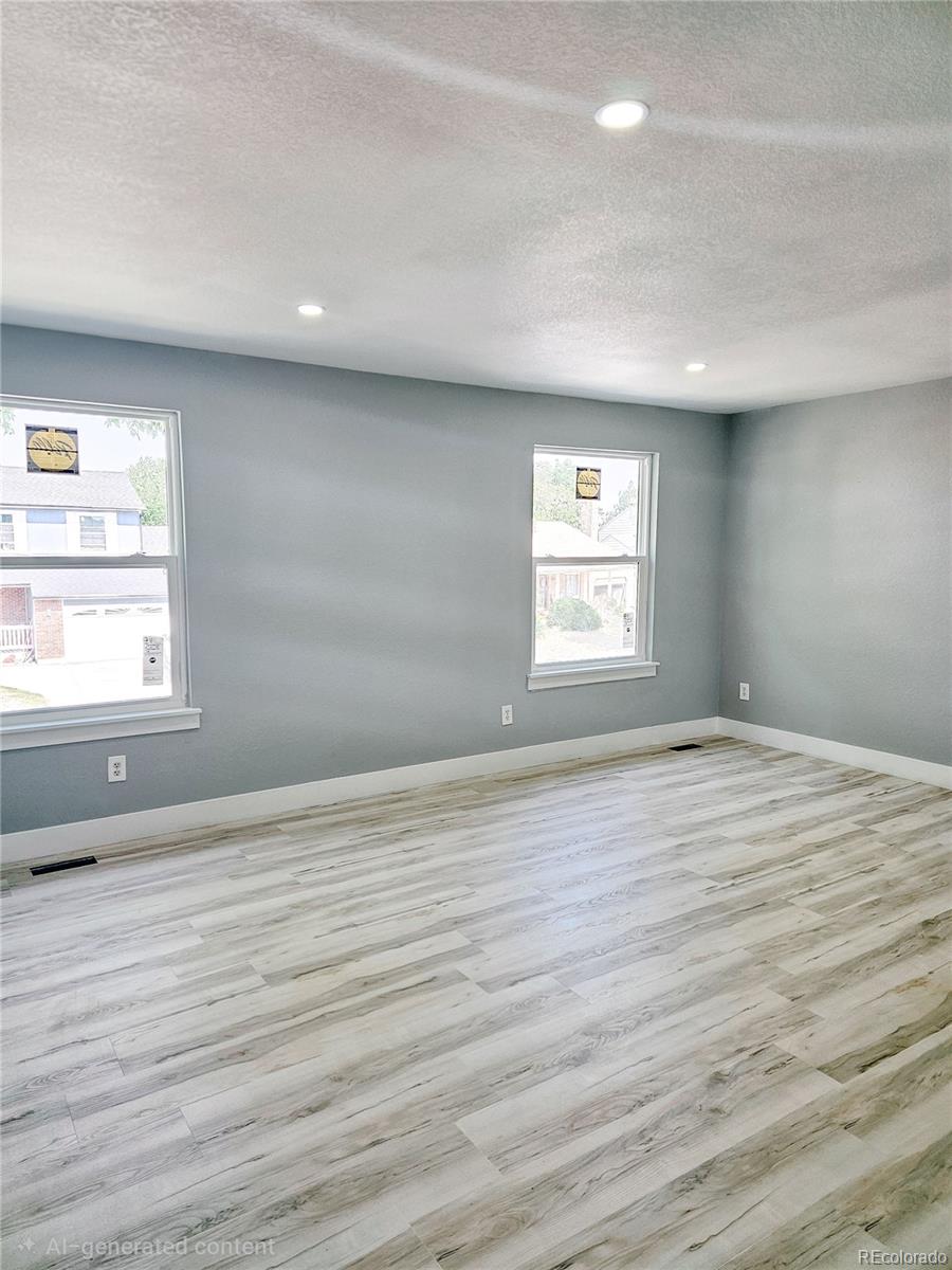 4716 Freeport Way Denver, CO 80239 - Photo 9 of 29 an empty room with wooden floor and windows
