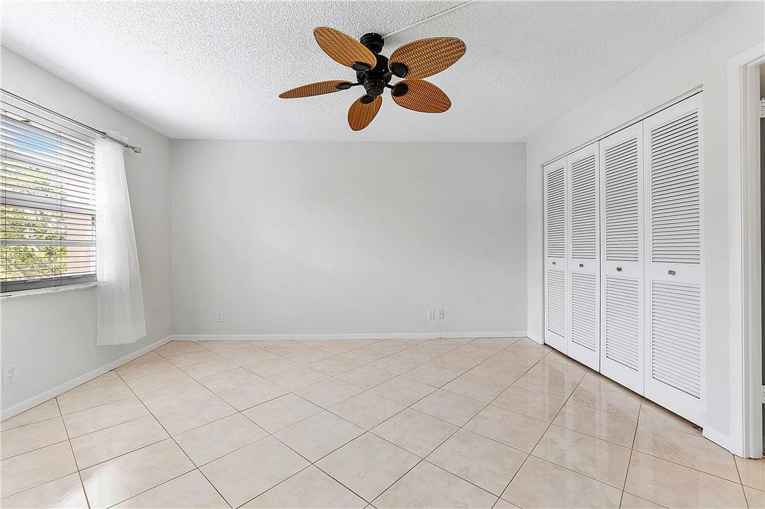 6100 Northwest 2nd Avenue, Unit 321 Boca Raton, FL 33487 - Photo 22 of 27 an empty room with chandelier fan and windows