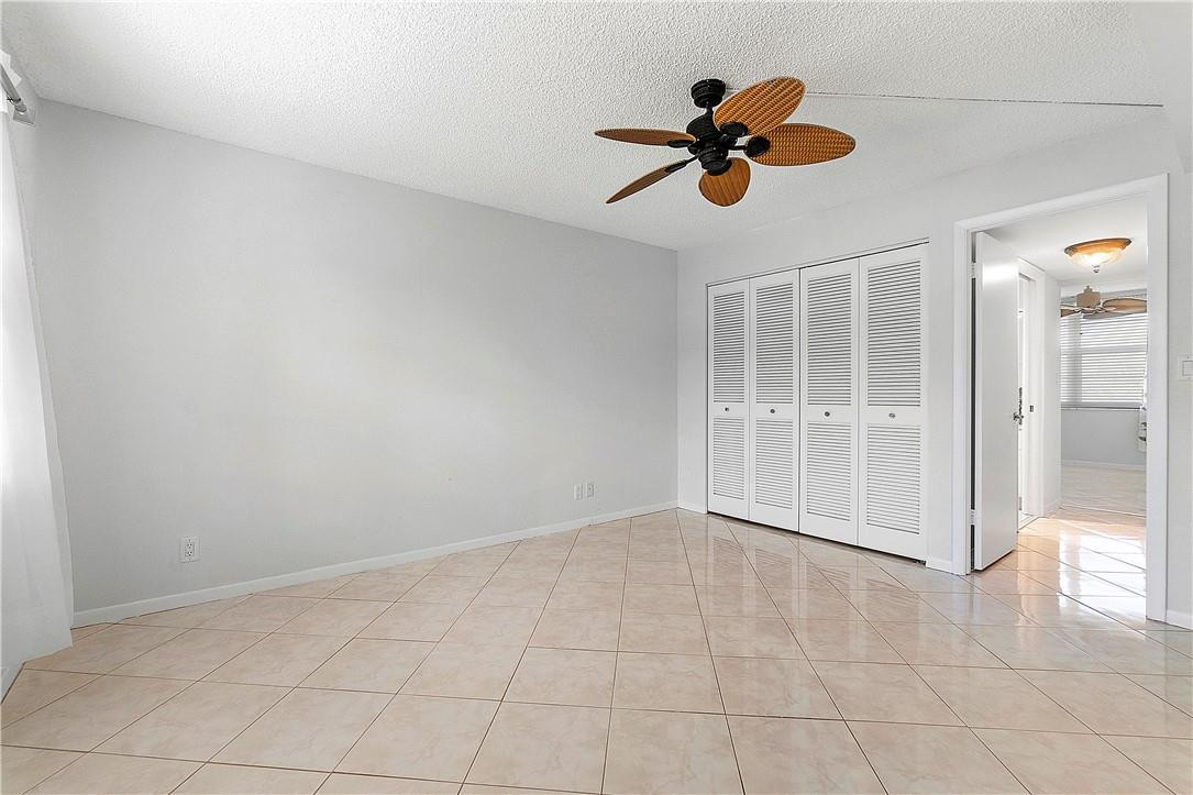 6100 Northwest 2nd Avenue, Unit 321 Boca Raton, FL 33487 - Photo 23 of 27 an empty room with wooden floor and chandelier fan