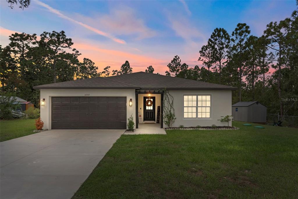 14347 Earline Road Weeki Wachee, FL 34614 - Photo 1 of 1 a front view of a house with a yard and garage