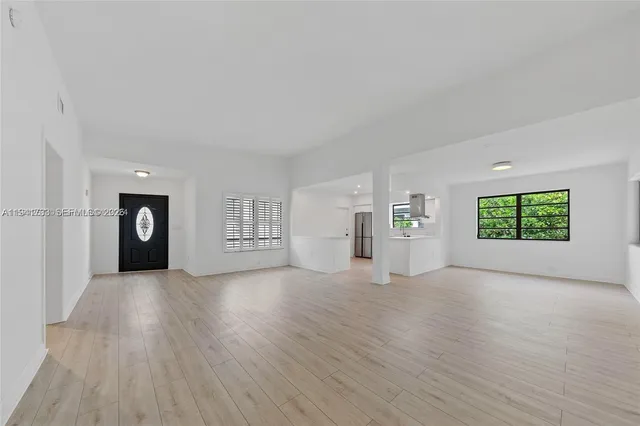 an empty room with windows and cabinet