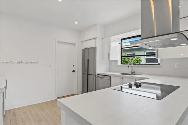 a kitchen with kitchen island a sink appliances and cabinets
