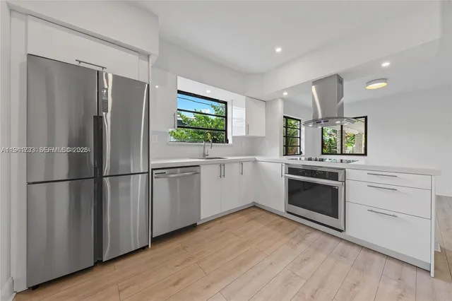 a kitchen with stainless steel appliances a refrigerator sink and stove