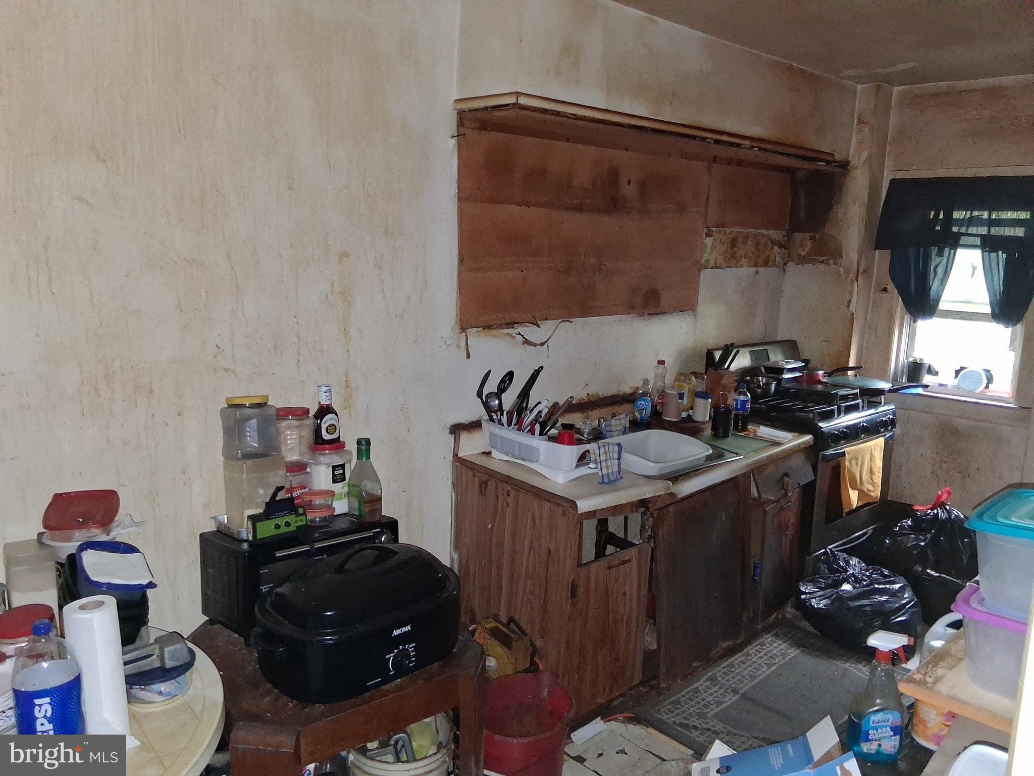 4035 Cedardale Road Baltimore, MD 21215 - Photo 15 of 40 a kitchen with a sink stove and cabinets
