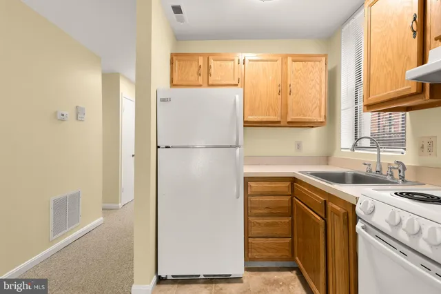 a kitchen with a refrigerator a stove a sink and a window