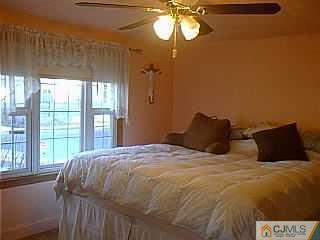 10 Fox Road Edison, NJ 08817 - Photo 4 of 8 a bedroom with a bed and a chandelier