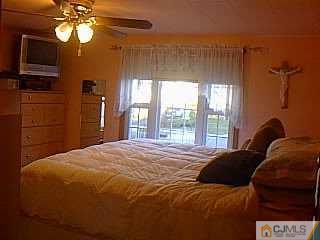 10 Fox Road Edison, NJ 08817 - Photo 5 of 8 a bedroom with a bed and a chandelier