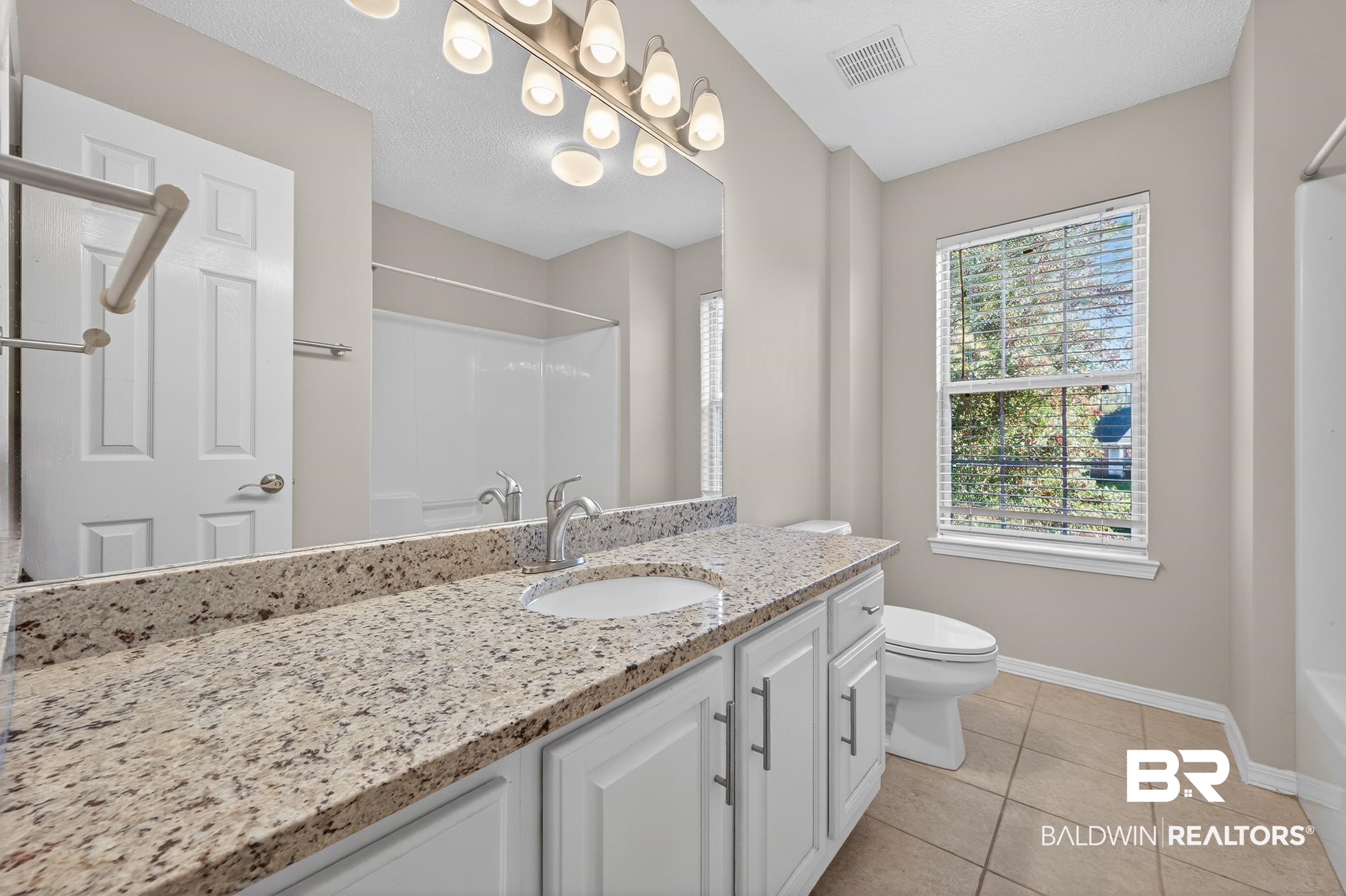 7050 Highpointe Place West Daphne, AL 36527 - Photo 52 of 66 Bathroom with vanity, light tile patterned floors, and a textured ceiling
