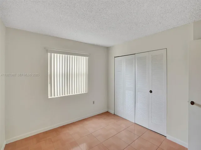 a view of a hallway with wooden floor and closet