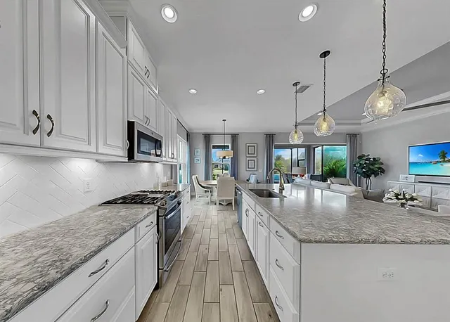 a open kitchen with stainless steel appliances granite countertop a sink stove and refrigerator