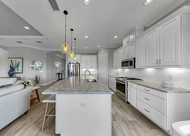 a dining room with kitchen island stainless steel appliances furniture a dining table and chairs