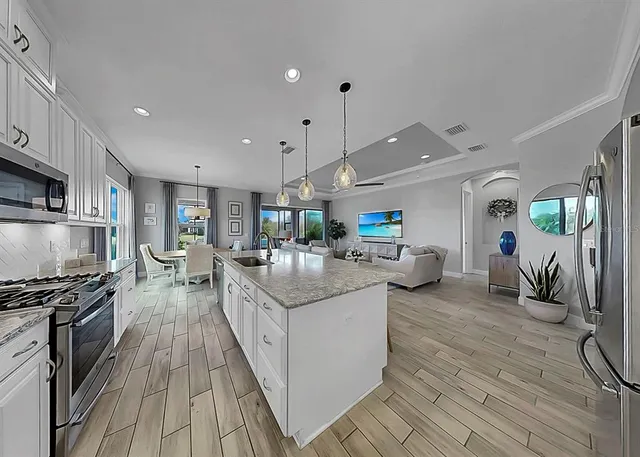 a kitchen with counter top space a stove a sink and a refrigerator