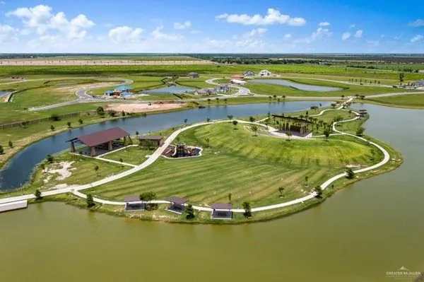 an aerial view of a house with a garden and lake view