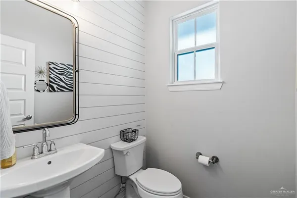 a bathroom with a toilet a sink and mirror