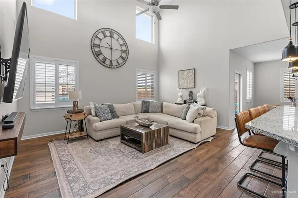 a living room with furniture a clock on wall and a window