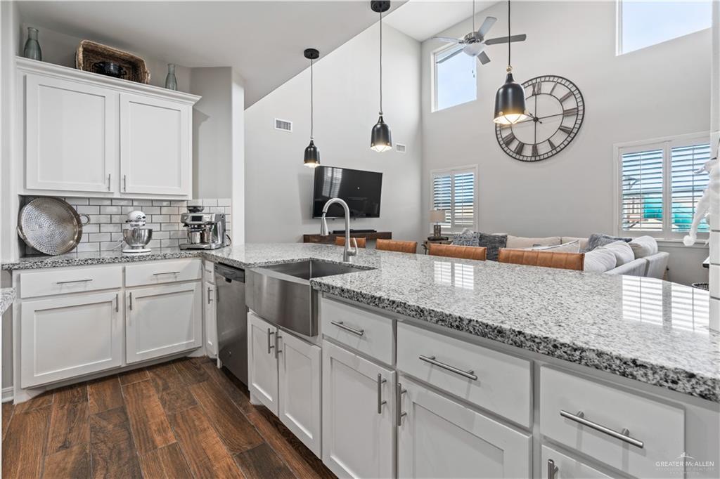 5508 River Road McAllen, TX 78504 - Photo 21 of 21 Kitchen with white cabinets, light stone countertops, dark wood-style floors, a high ceiling, and open floor plan