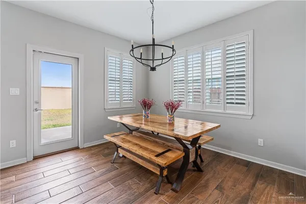 a very nice looking kitchen with granite countertop a stove a sink and dishwasher wooden cabinets with wooden floor