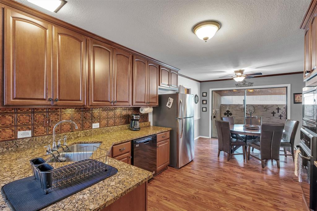 112 Two Feather Whitney, TX 76692 - Photo 23 of 40 House #1 kitchen, looking toward a breakfast or serving area and a sliding door to a small fenced yard