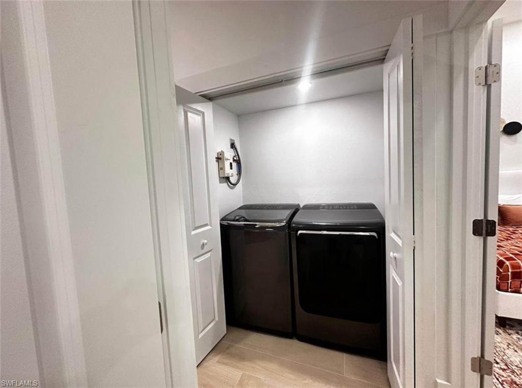 2881 Santa Barbara Boulevard Naples, FL 34116 - Photo 15 of 15 Laundry room featuring washing machine and clothes dryer and light tile patterned flooring