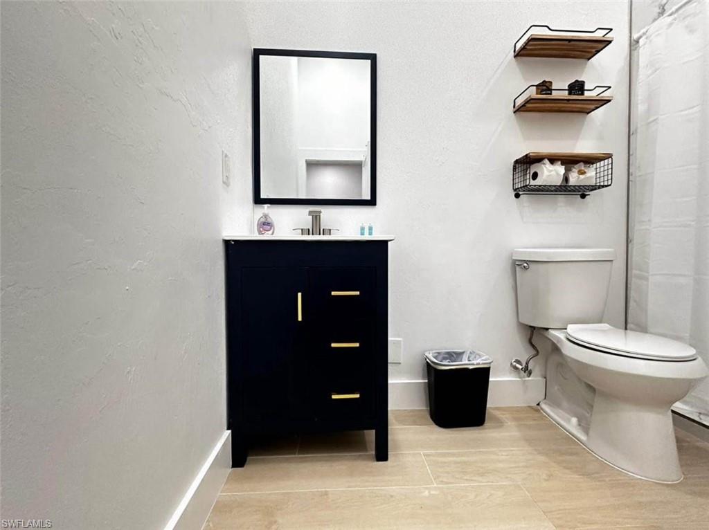 2881 Santa Barbara Boulevard Naples, FL 34116 - Photo 6 of 15 Full bath featuring toilet, baseboards, vanity, and tile patterned flooring