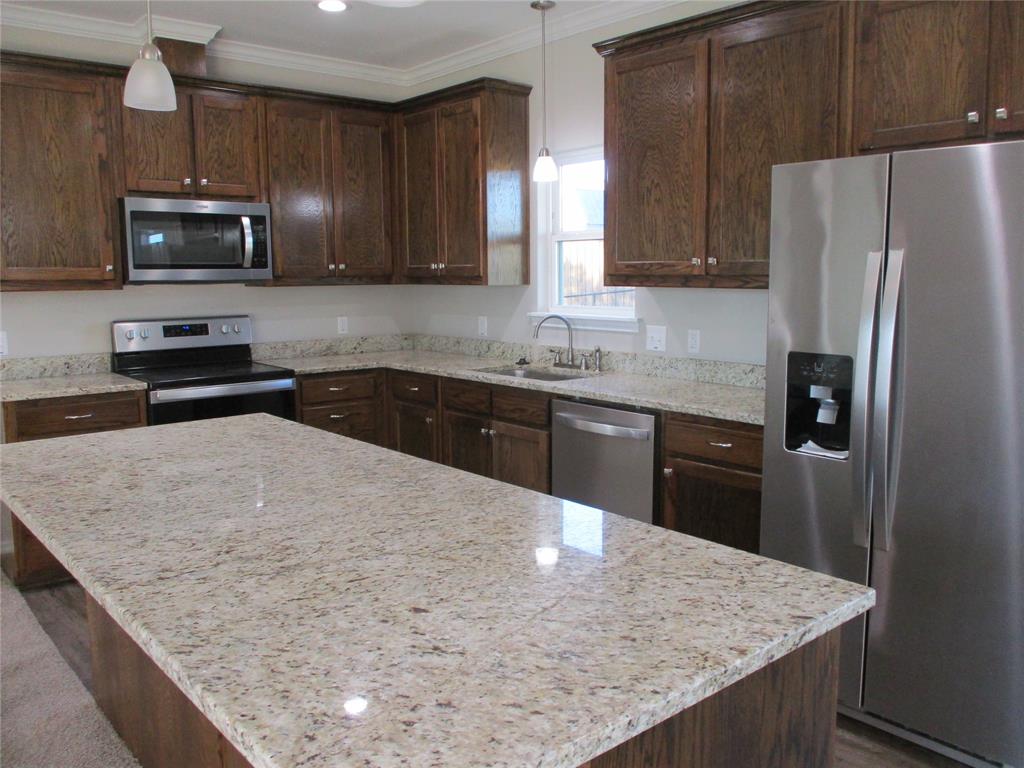 207 Mill Street Emory, TX 75440 - Photo 14 of 34 a kitchen with stainless steel appliances granite countertop a sink stove microwave and refrigerator