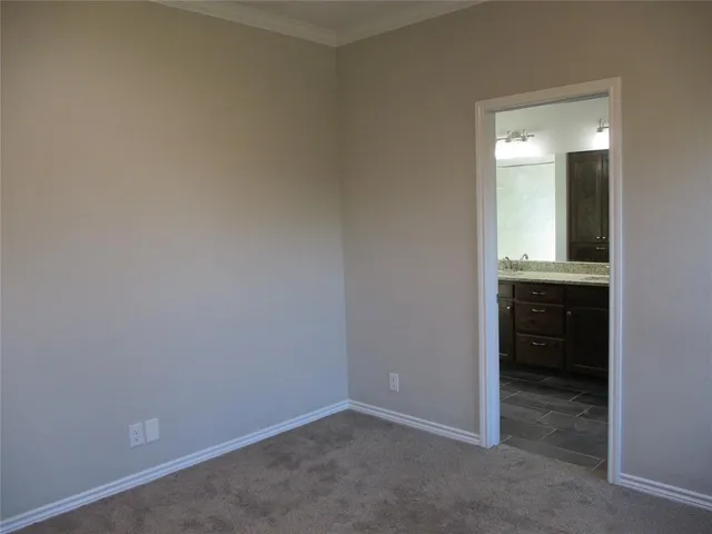 an empty room with a bathroom and sink