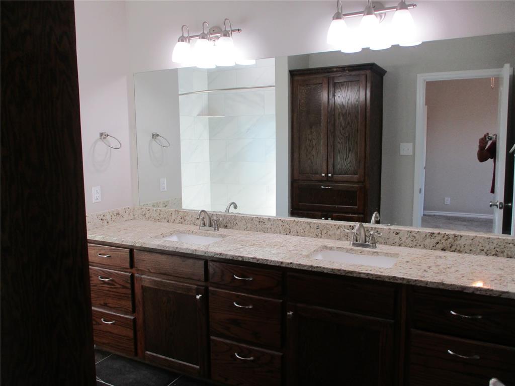 207 Mill Street Emory, TX 75440 - Photo 20 of 34 a bathroom with a granite countertop sink and a mirror