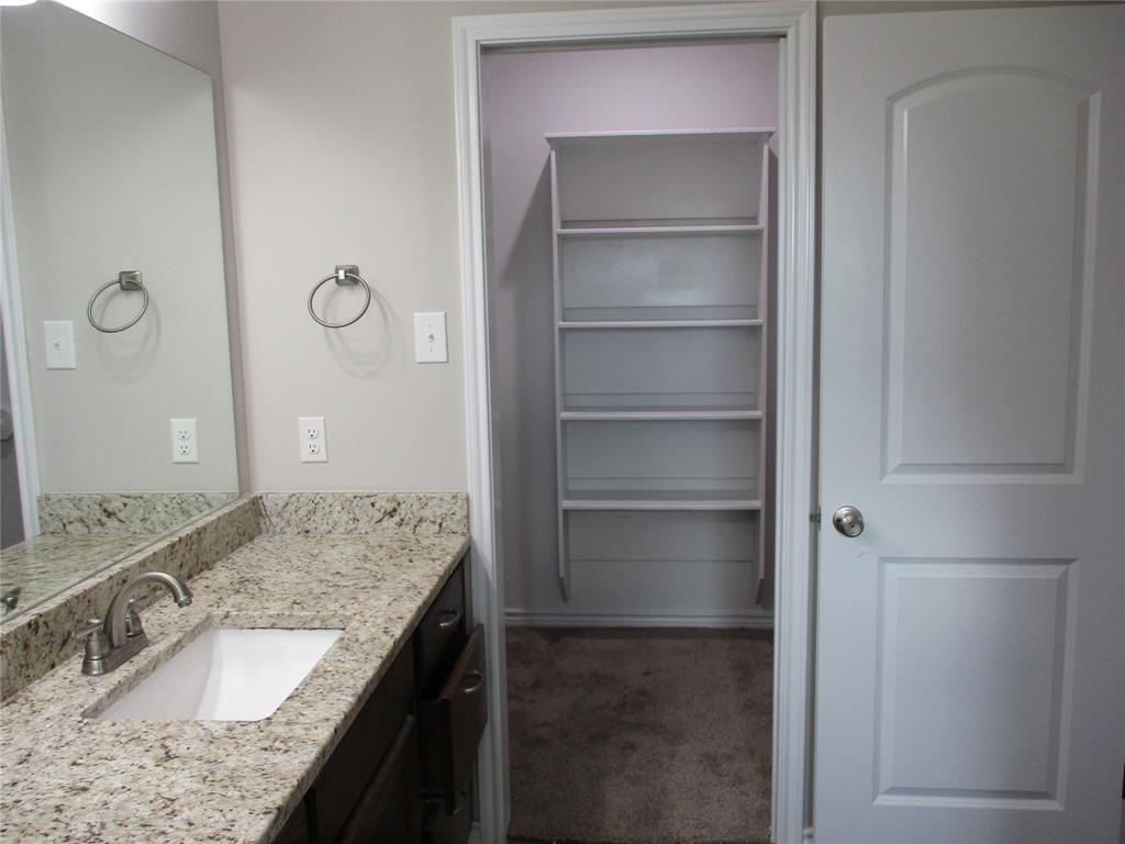 207 Mill Street Emory, TX 75440 - Photo 21 of 34 a bathroom with a granite countertop sink and a mirror