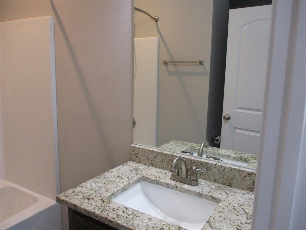 207 Mill Street Emory, TX 75440 - Photo 28 of 34 a bathroom with a granite countertop sink and a mirror