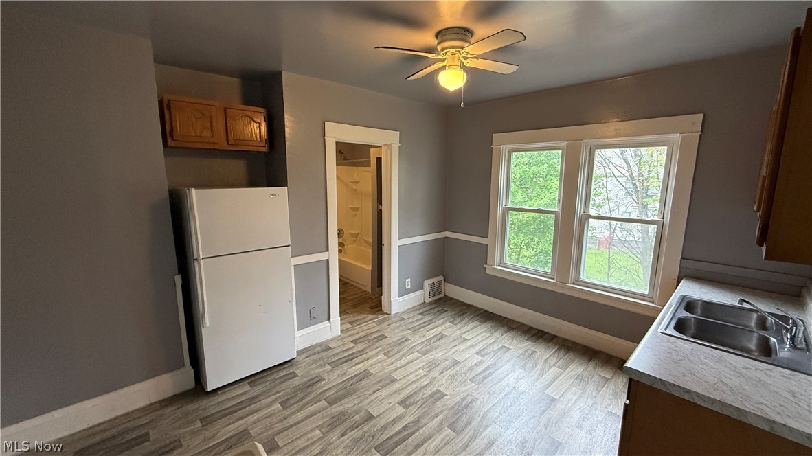 1187 Addison Road, Unit 4 Cleveland, OH 44103 - Photo 3 of 15 Spacious room featuring wood-finish flooring, a contemporary ceiling fan, and two large double-hung windows