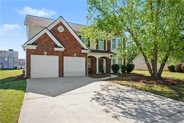 a front view of a house with a yard and garage
