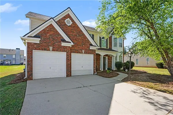 a front view of a house with a yard and garage