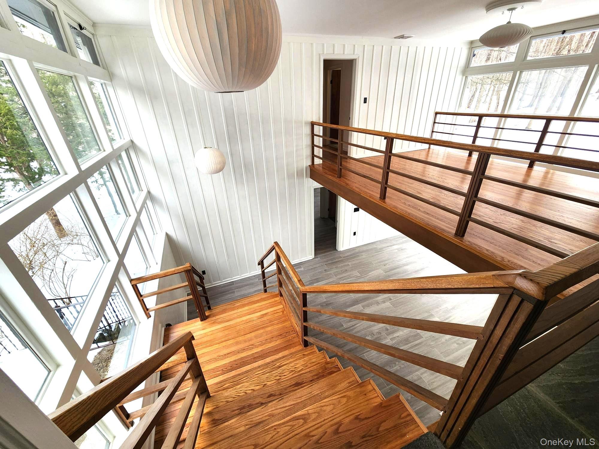 568 River Road Rhinebeck, NY 12572 - Photo 15 of 26 Staircase featuring plenty of natural light, wood finished floors, and wood walls