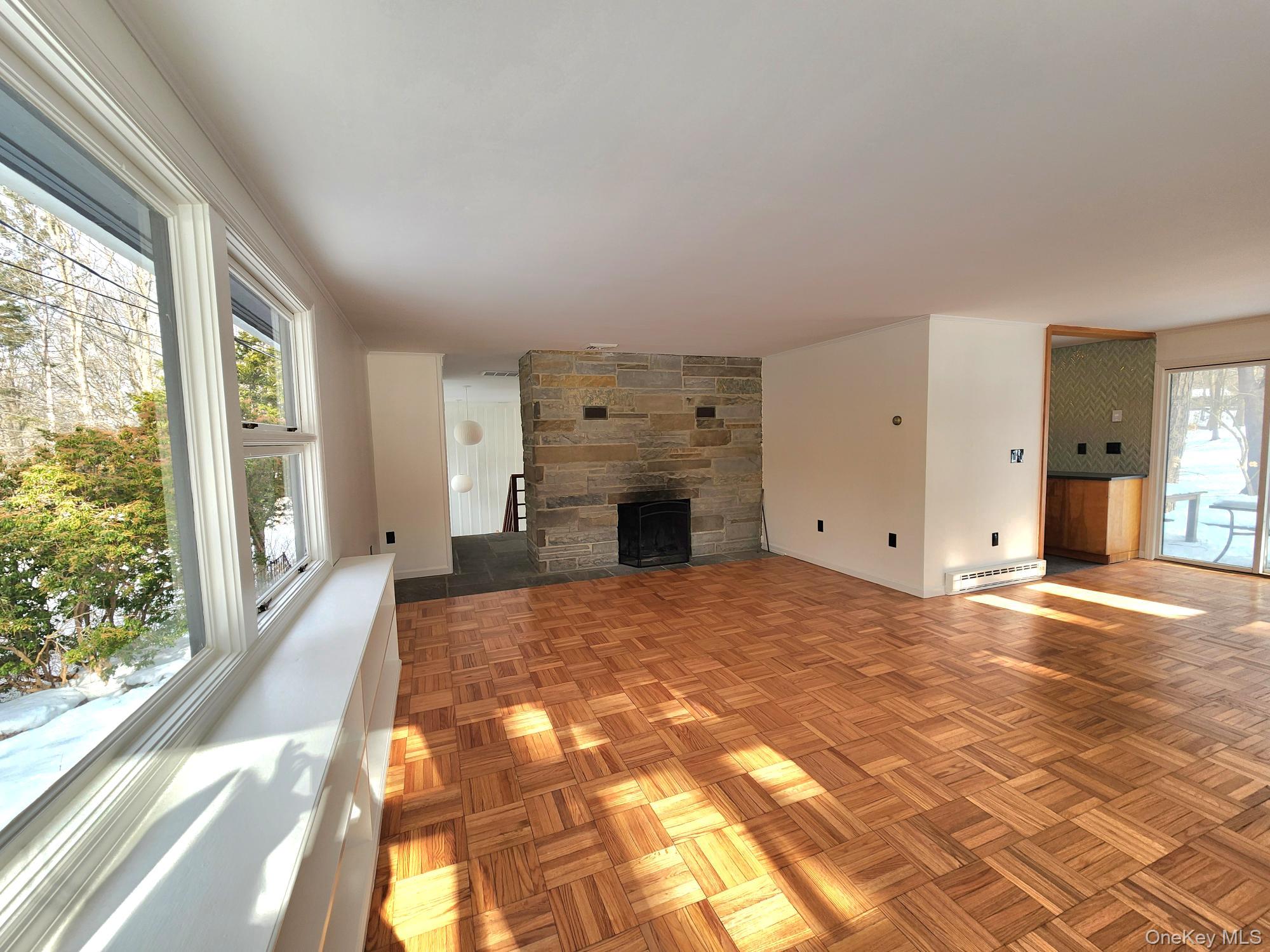 568 River Road Rhinebeck, NY 12572 - Photo 8 of 26 Unfurnished living room with a stone fireplace, parquet flooring, and baseboard heating