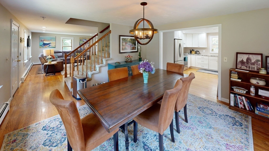 20 Staples Shore Road Lakeville, MA 02347 - Photo 9 of 39 a dining room with wooden floor a chandelier a wooden table and chairs