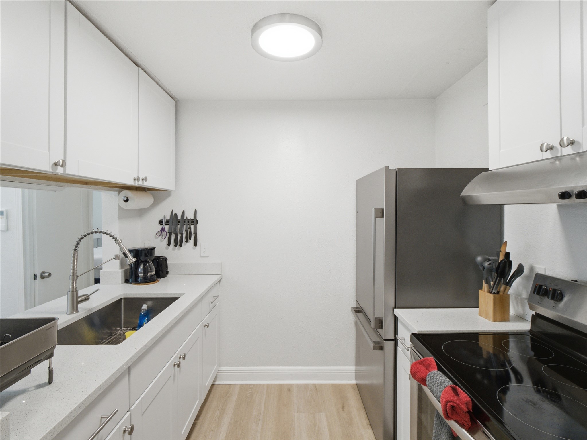 1108 Jolena Circle Austin, TX 78721 - Photo 5 of 21 A well-lit culinary space features bright white cabinetry and stainless-steel appliances.