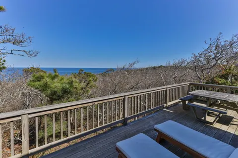 a view of a balcony with wooden floor and outdoor seating
