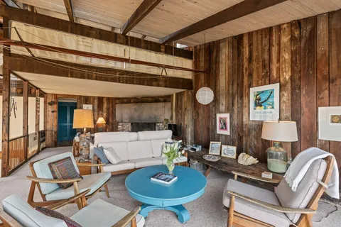 a living room with couches and a dining table with kitchen view