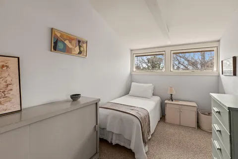 a bedroom with a bed and a painting on the wall