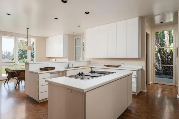 a kitchen with a stove a sink a microwave a dining table and chairs