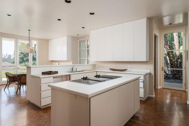 a kitchen with a stove a sink a microwave a dining table and chairs