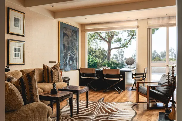 a living room with furniture a table and a large window