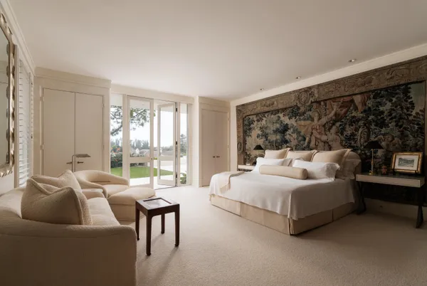 a spacious bedroom with a bed couch and a large window